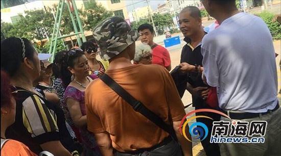 在海南热带飞禽世界景点外的停车场，导游和其助手两人就要求游客缴纳850元费用。南海网记者组 摄