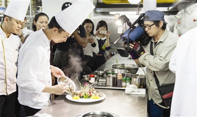 台湾《尝鲜Let’s go!》节目组来岚 展现平潭传统民间佳肴(图1) 节目组的摄像师正在厨房拍摄美食烹饪过程